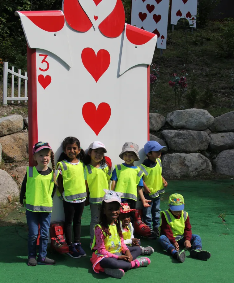 Groupe d'enfants en dossards devant une carte à jouer géante de cœur