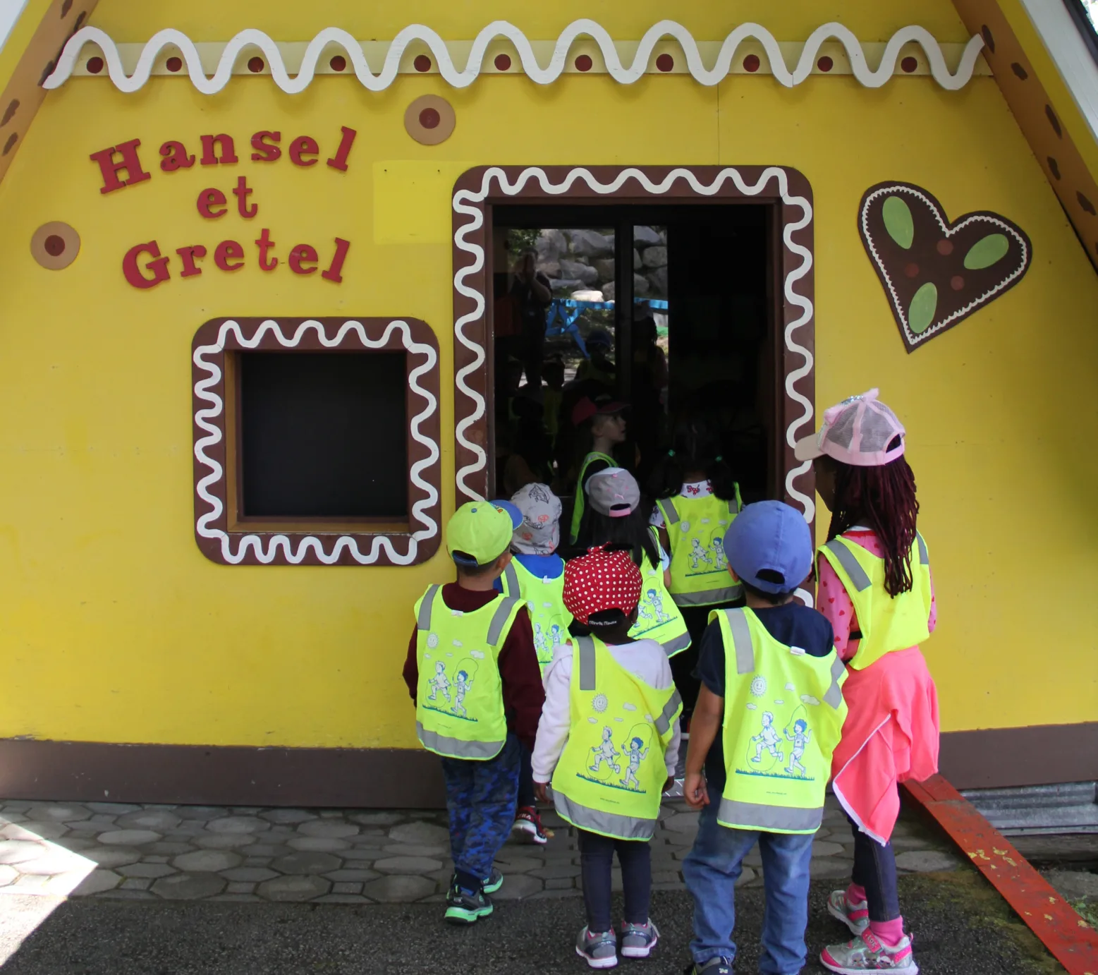Des enfants en dossards entrent dans la maison en pain d'épice de Hansel et Gretel